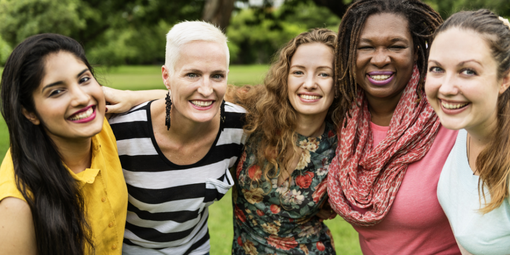 A group of five women posing for the camera.