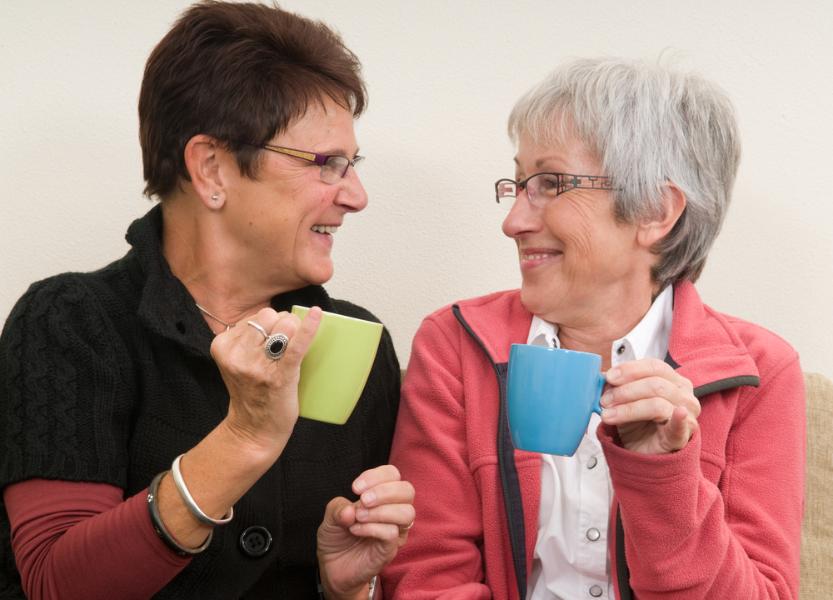 Two women holding cups with their little finger up