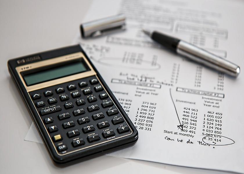 A calculator with a sheet of paper with numbers on it and a pen