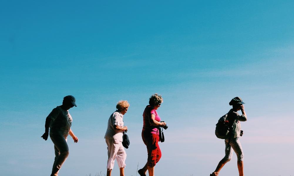 A group of ladies walking with a blue background