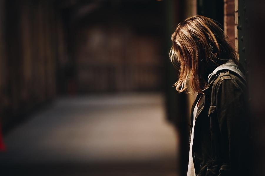 A girl stands in a dimly lit hallway on Alcatraz Island