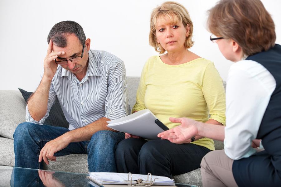 Mature couple getting financial advice from consultant at home