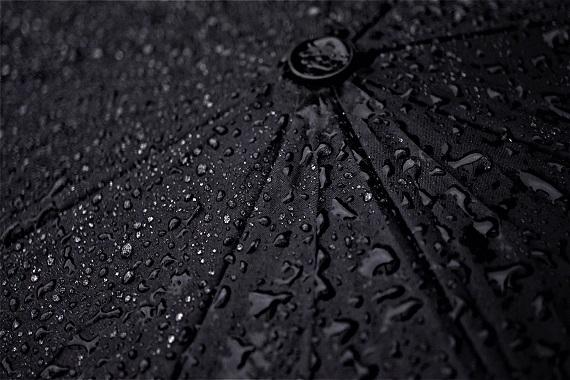 A black umbrella with rain drops on it