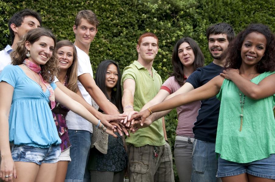 A group of young adults with their hands on top of each other